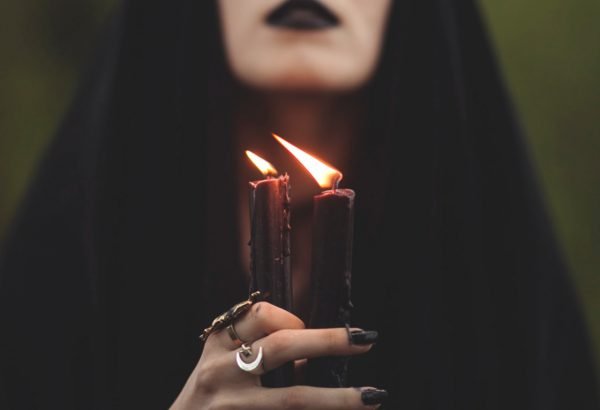 Чёрные свечи в руках женщины